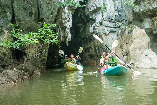 Paddling out of one of the caves carved by nature right through the mountains